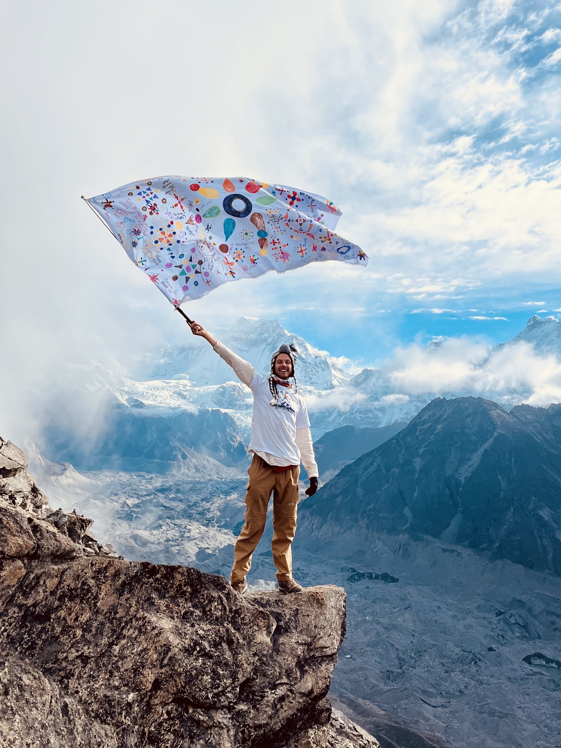 Brook Tate at Mount Everest, waving the Multicolour Maths flag