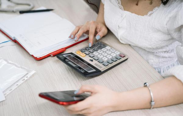 A person using a calculator and a mobile phone
