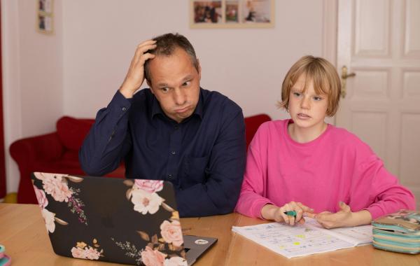 Parent and child struggling looking at a laptop