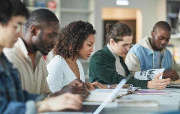 Five students are studying together at a table