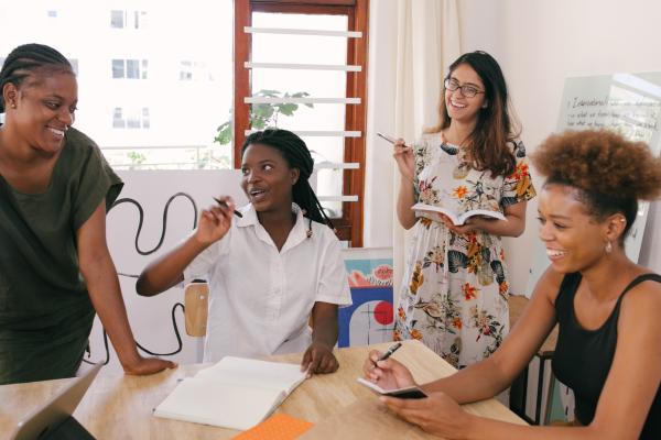 Stock image of adults around a table with a laptop